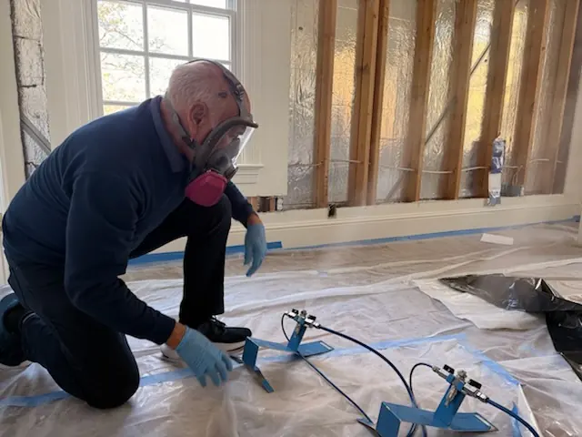 A restoration technician setting drying equipment in a Vista home stripped to the studs