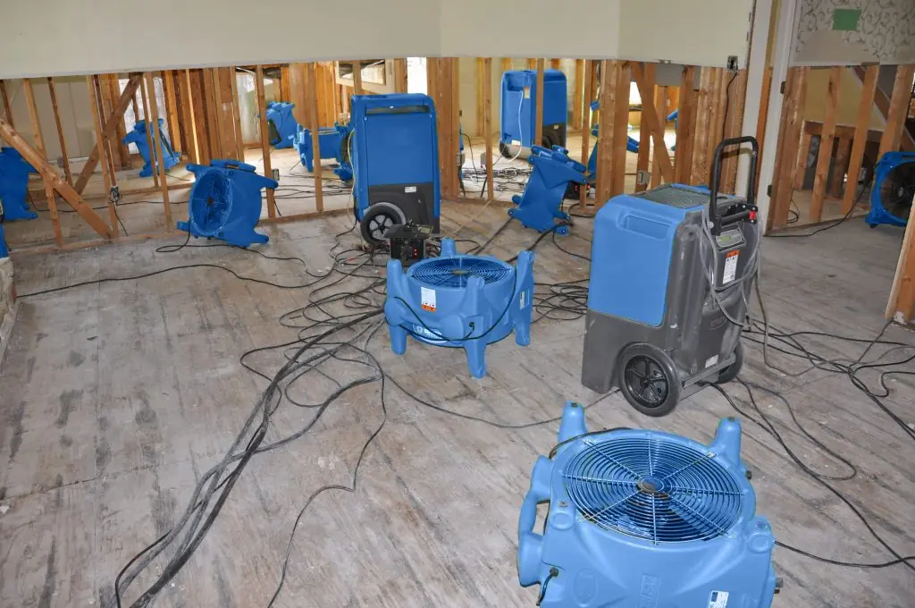 Air movers drying a gutted Vista room after major water damage